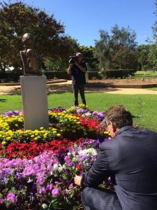 Ted Baillieu placing a rose at the base of the memorial statue of Mother and Child